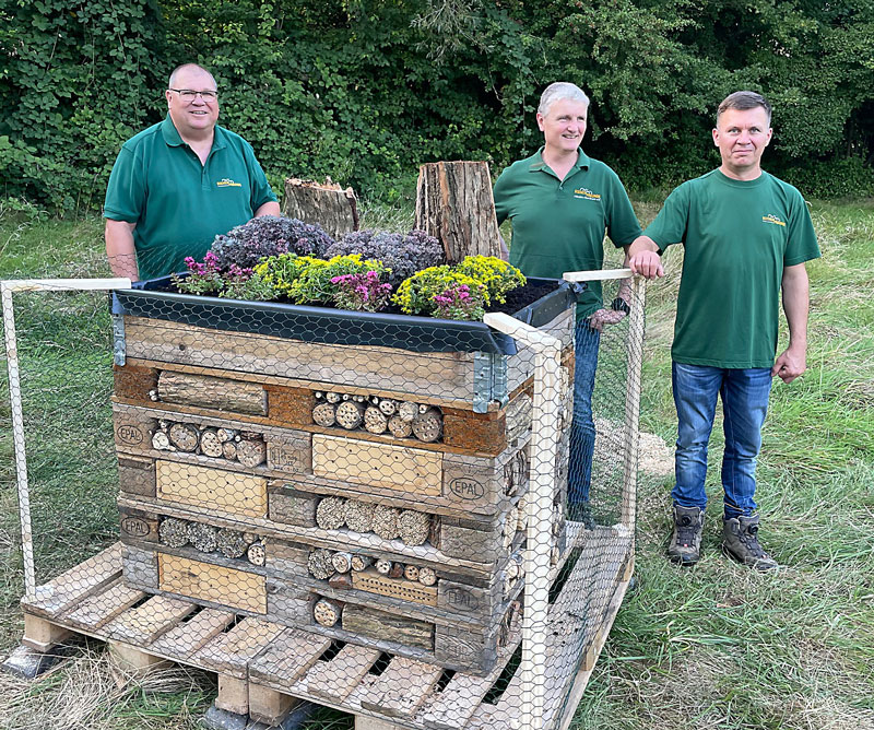 Die Hobbyimker Rolf Kretschmer (v. l.), André Becker und Vladimir Stolinski präsentieren das fertige Wildbienenhotel inklusive bienenfreundlicher Bepflanzung und umlaufendem Vogelschutzdraht.